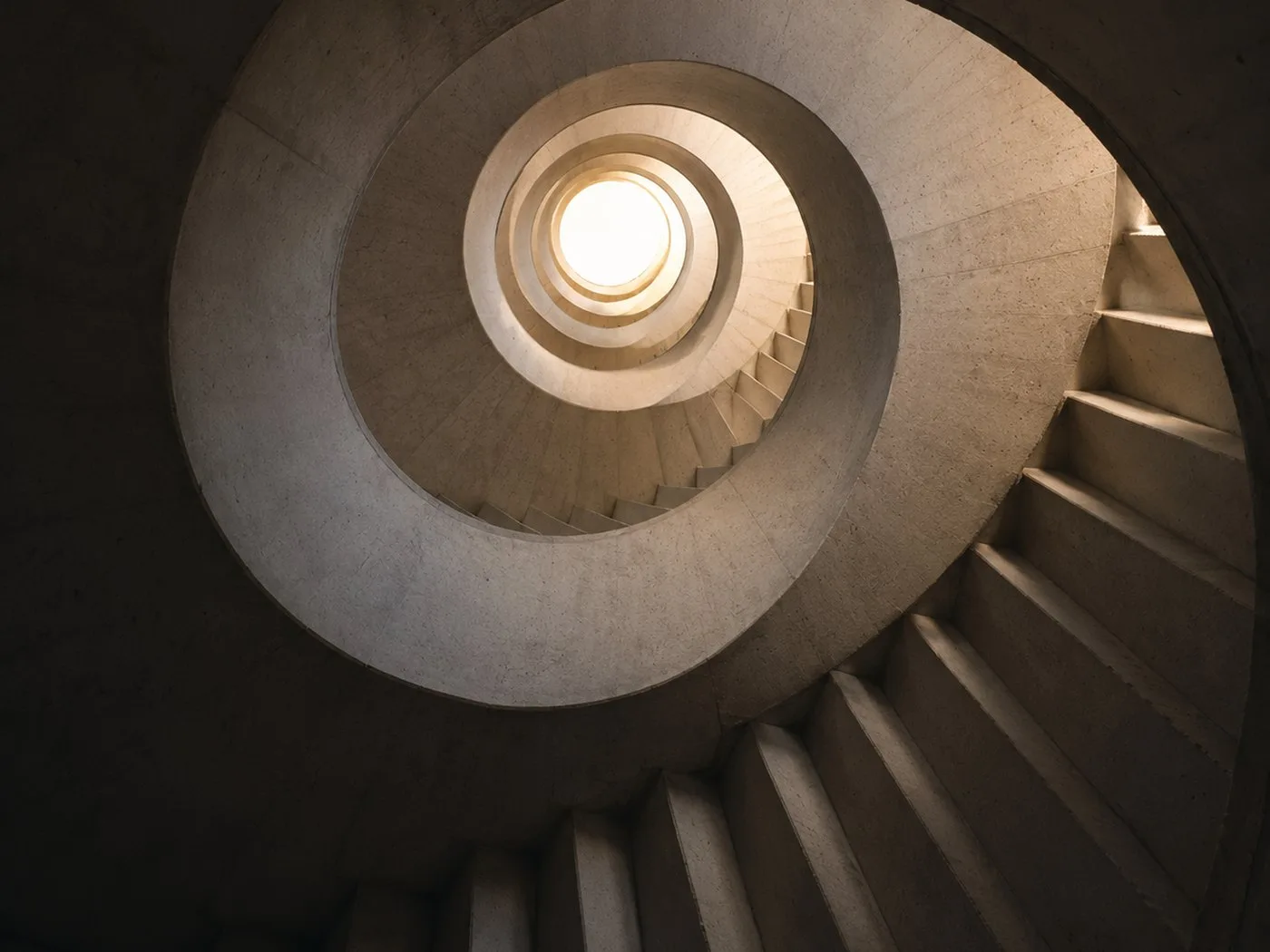 Wendeltreppe von unten, die sich zu einem hellen Oberlicht windet